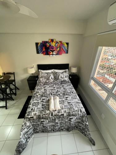 里贝朗普雷托Studio completo e aconchegante的一间卧室配有一张带黑白色床罩的床。