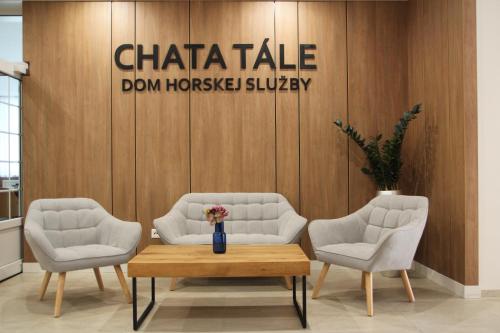 塔莱Chata Tale - Dom Horskej služby的大堂设有两把椅子、一张桌子和一个标志
