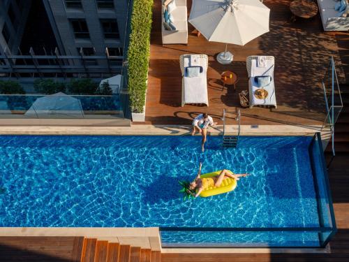 迪拜迪拜国际金融中心四季酒店的两个人在一个带木筏的游泳池里