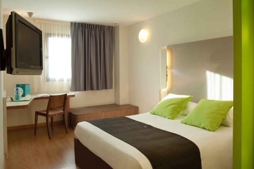 马拉加钟楼马拉加机场酒店的配有一张床和一张书桌的酒店客房