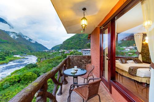 巴尼奥斯Aldea Real Eco Friendly的客房设有带一张床和一张桌子的阳台。