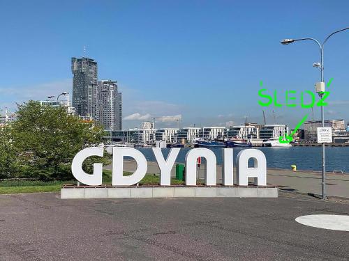 格丁尼亚Śledź Gdynia - YACHT PARK的城市里的一个大标志,上面写着gpxaho