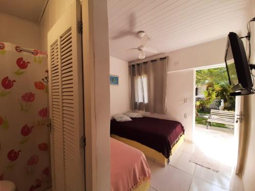瓜鲁雅PousadaRecanto684Guarujá的一间卧室设有一张床和一个滑动玻璃门