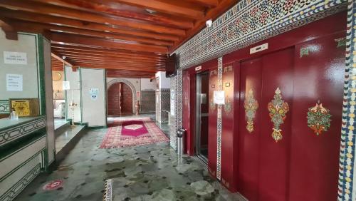 马拉喀什伊米勒希勒格兰德酒店的走廊上设有红色的墙壁和红色的门