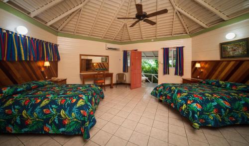 尼格瑞尔Samsara Cliff Resort的一间卧室配有两张床和吊扇