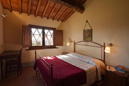 卡斯德尔诺沃贝拉登卡Agriturismo Podere Fornacino的一间卧室配有一张床、一张桌子和一个窗户。