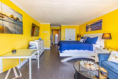 默特尔比奇Sand Dunes 2740的卧室拥有黄色的墙壁,配有一张床和一张沙发