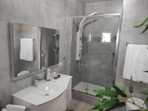 奥罗塞伊Romantico open space Luna的带淋浴、盥洗盆和镜子的浴室