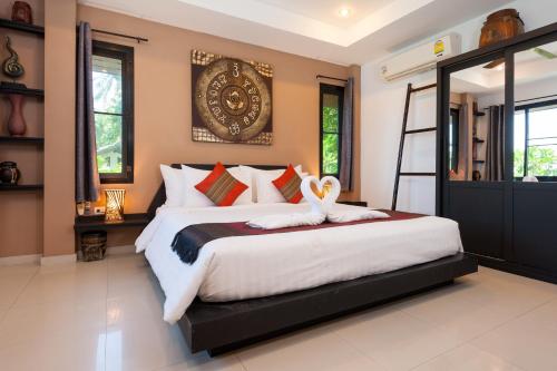 涛岛柯岛高地精品别墅酒店的一间卧室配有一张大床,上面有两个天鹅