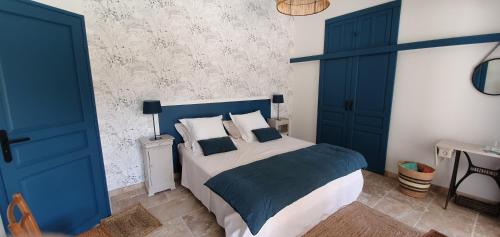 莱博德普罗旺斯MAS DE LA FADETO的卧室设有蓝色门和一张带枕头的床