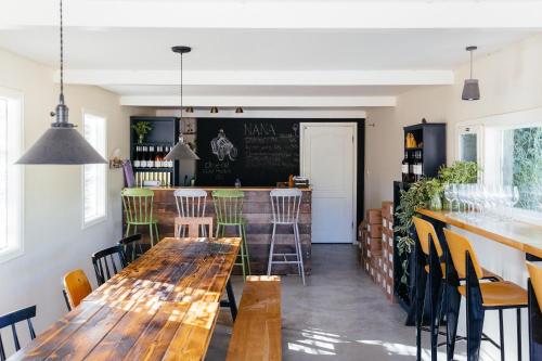 米茨佩·拉蒙פטריוט -יקב ננה的一间带木桌椅的餐厅和一间酒吧