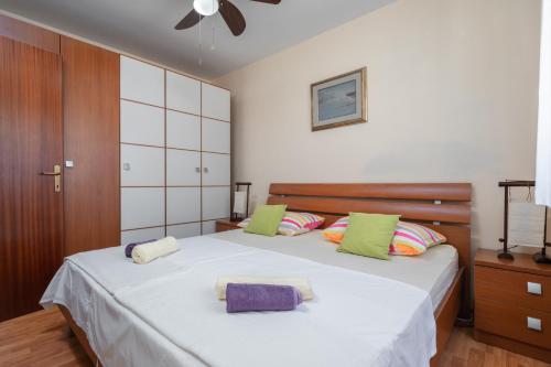 尼亚卢卡kuća za odmor Tino的一间卧室配有一张大床,提供绿色和紫色枕头