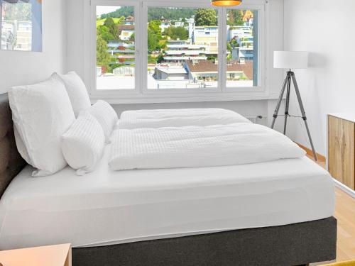 楚格ARISER - Mountain View Business Apartment的一张带白色床单和枕头的床