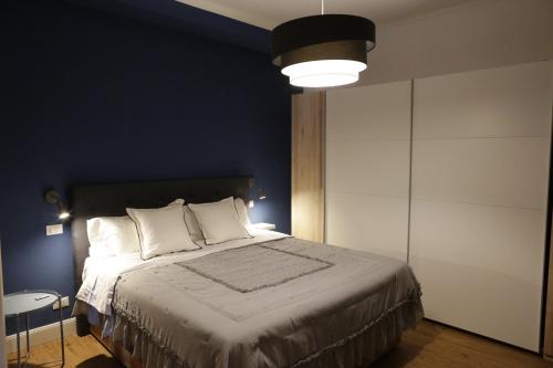拉奎拉CasaMica L'Aquila的一间卧室设有一张蓝色墙壁的大床