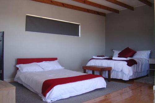 CrawleySuite Ruby Tuesday - Capri的一间卧室配有两张红色和白色床单