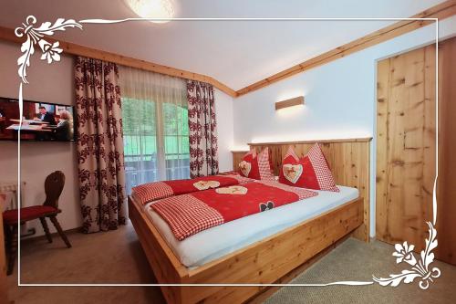 罗孚尔Haus Bartlmä的一间卧室配有一张红色棉被的床