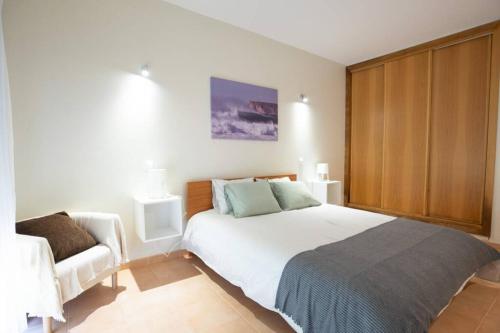 萨格里什sagres apartment best location beach and town life的卧室配有一张白色的大床和一张沙发。