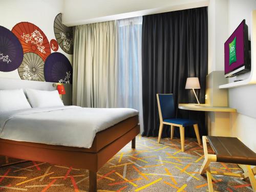 玛琅马朗宜必思尚品酒店的酒店客房配有一张床、一把椅子和一张书桌
