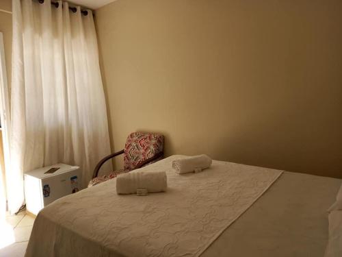 迪亚曼蒂纳Hospedagem em Diamantina的一间卧室配有一张带椅子的床和一扇窗户