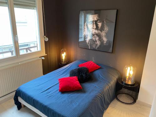 维姆勒Le 37的一间卧室配有一张带蓝色床单和红色枕头的床。