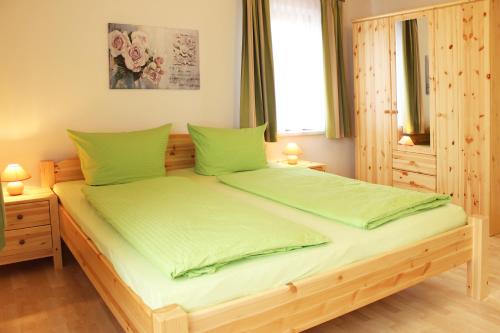 ZirchowFerienhaus Segebrecht的一间卧室配有一张带绿色床单的木床。