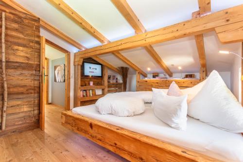 萨菲登安斯泰内嫩米尔Ferienwohnung Maisonette Höttl的卧室配有带白色枕头的大型木质床。