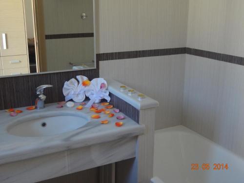 卡利斯托斯Aegea Hotel的浴室设有水槽,上面装有药丸和鲜花