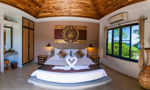 涛岛龟岛高地泳池别墅酒店的一间卧室设有一张带木制天花板的大床