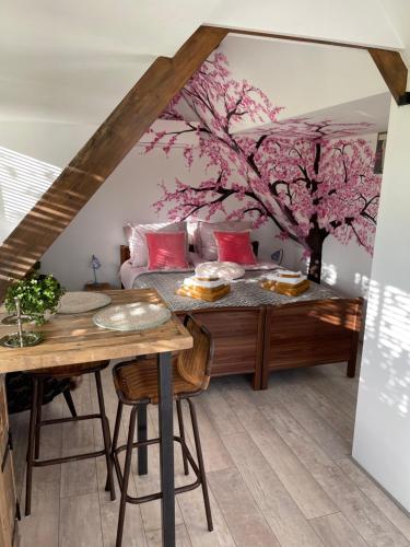 德拉赫滕B&B Bijzonder的一间设有桌子和一棵鲜花树的用餐室