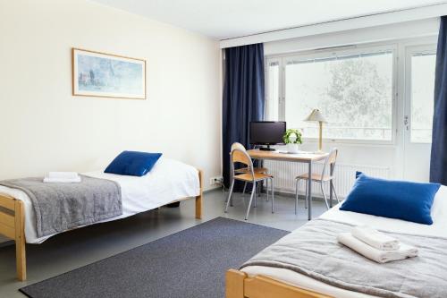 约恩苏ISLO Hostel的酒店客房配有两张床和一张书桌