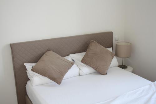 曼海姆Apartment 1的一间卧室配有带白色床单和枕头的床。