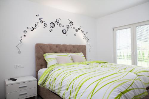 莫斯特拉纳Bella Belca的一间卧室配有一张带绿色和白色棉被的床