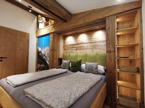 瑟尔Bauernhof Unterstegen的卧室配有木墙内的一张床