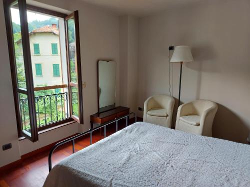 Brinzio洛坎达德布林斯柯旅馆的一间卧室配有两把椅子、一张床和窗户