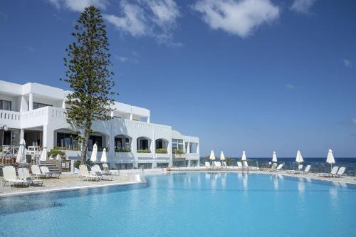 锡西马里迪莫海滩酒店 的游泳池位于酒店前,配有椅子