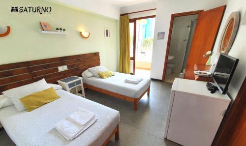 卡拉米洛萨图尔诺酒店的酒店客房设有两张床和电视。