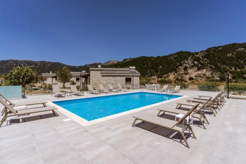 奥马洛斯奥马洛斯村别墅的一个带躺椅的游泳池,一个度假胜地