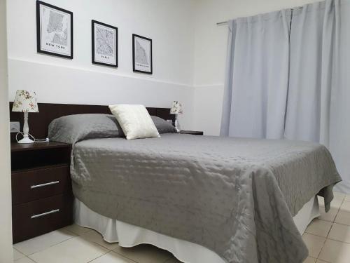 卡塔马卡Apart Ocampo Catamarca II的一间卧室配有一张床,床头柜配有两盏灯