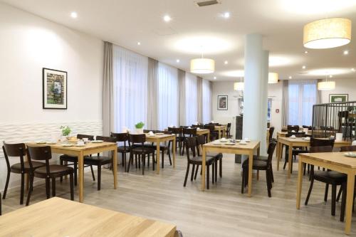 柏林柏灵商业酒店的用餐室配有木桌和椅子