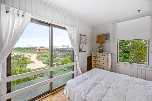 海洋海滩Robbins Rest Retreat的一间卧室设有一张床和一个大窗户