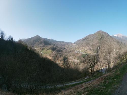 BoutxCabane dans un pommier的享有山脉和道路的景色