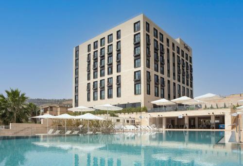 提比里亚Sofia Hotel Sea Of Galilee的大楼前设有大型游泳池的酒店