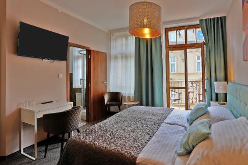 卡罗维发利Hotel Pilgrim的酒店客房配有一张床、一张书桌和一台电视。