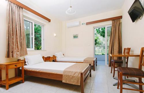 卡梅纳维洛拉Hotel Loula Rooms and Apartments的一间酒店客房,设有两张床和电视