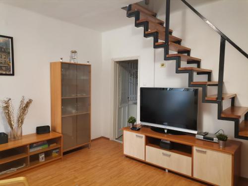 巴拉顿博格拉尔Edina-ház的一间带电视和楼梯的客厅