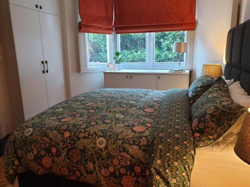 伦敦St Paul's Studios apartment的一间卧室配有一张带毯子的床和窗户