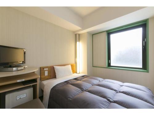 大阪R&B Hotel Umeda East - Vacation STAY 40693v的酒店客房,配有床和电视