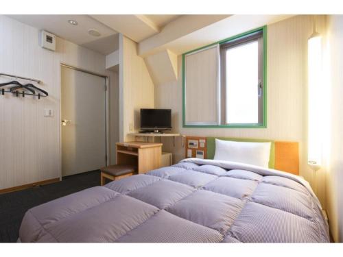 神户R&B Hotel Kobe Motomachi - Vacation STAY 40715v的一间卧室设有两张床、一张桌子和一个窗口。