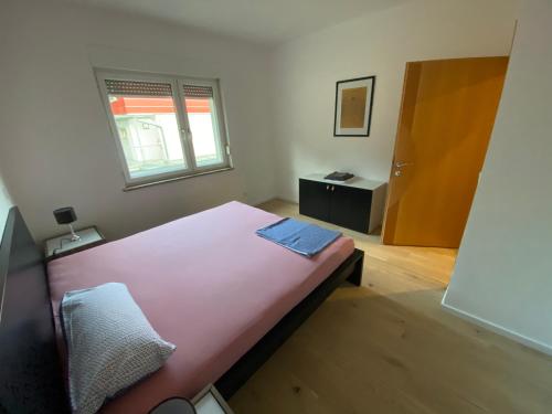 格拉特科恩Apartment mit Parkblick的卧室设有一张粉红色的大床和一扇窗户。