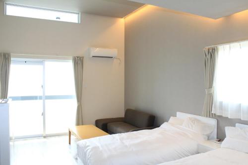 名户Gate into Nago - Vacation STAY 49102v的酒店客房,配有两张床和椅子